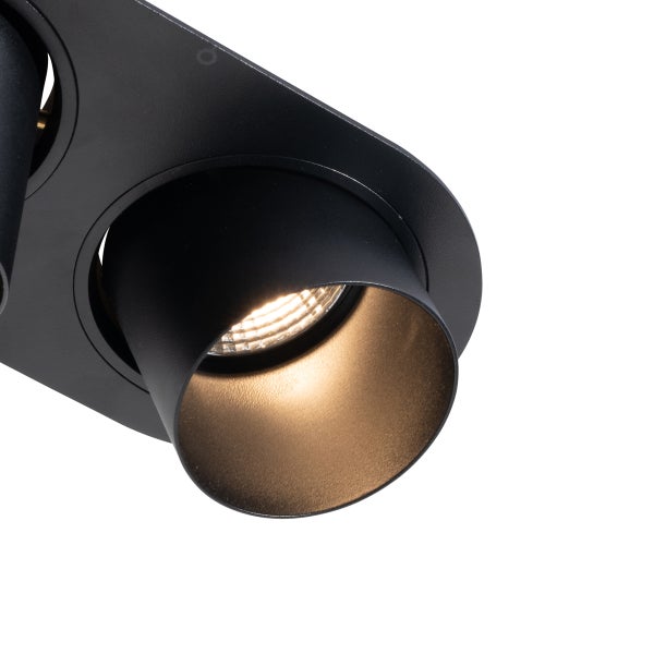 Detailansicht eines schwarzen Deckenstrahlers mit eingeschaltetem Leuchtmittel und goldfarbenem Innenreflektor.