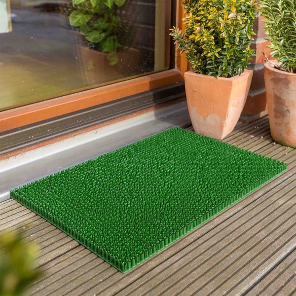 Grüne Fußmatte mit Noppen vor einer Tür