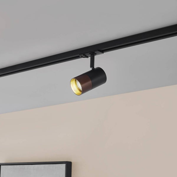 Schienensystem-Strahler in Schwarz und Holzoptik mit goldener Innenseite an einer Deckenschiene.