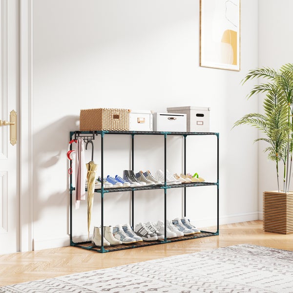 Schwarzes Metall-Schuhregal mit drei Ebenen in einem hellen Flur, bestückt mit Schuhen, Aufbewahrungsboxen und Zubehör wie Regenschirm und Schal.