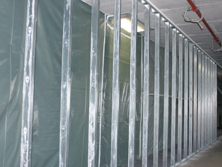 Ständerwerk aus Metallprofilen für eine Trockenbauwand mit montierter Dampfsperrfolie in einem Innenraum