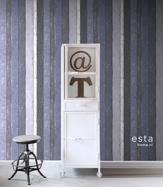 Raumansicht mit Holzpaneel-Tapete, weißem Metallschrank und Hocker