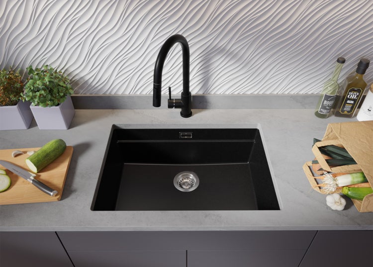 Schwarzes Spülbecken mit Armatur in einer modernen Küche mit Gemüse