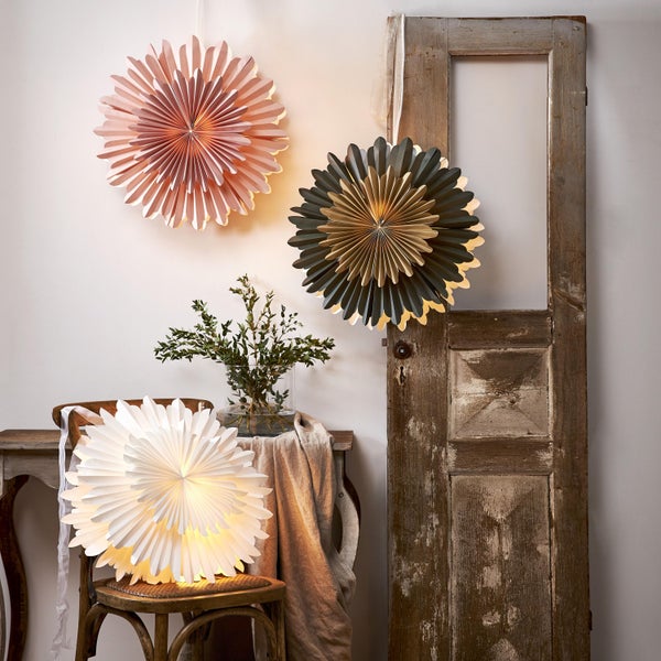 Dekorative Papierschirme hängen in einem Raum, der mit einer Vintage-Tür und Möbeln dekoriert ist.