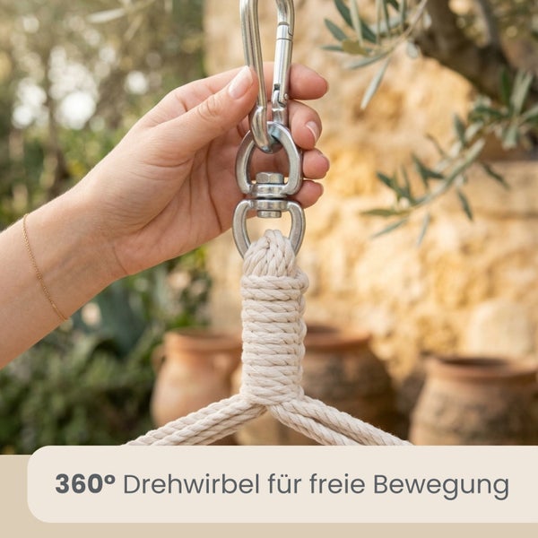 Ein 360 Grad Drehwirbel aus Metall verbindet ein Seil mit einem Karabinerhaken für freie Beweglichkeit im Garten.