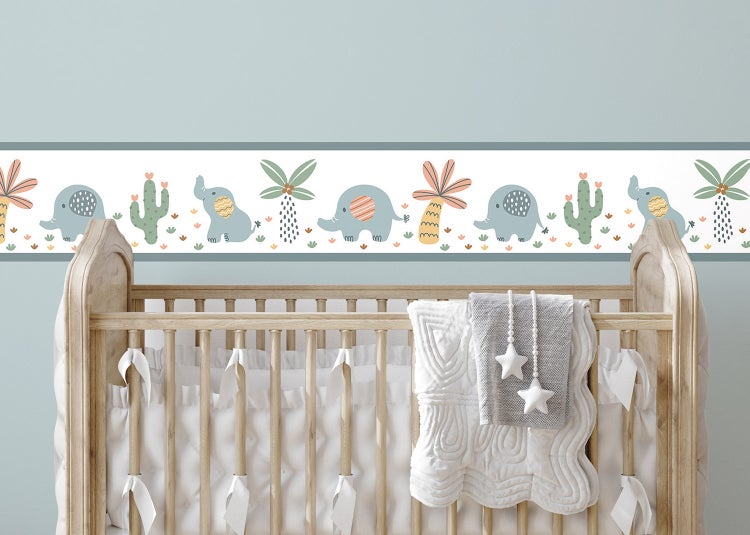Tapetenbordüre für das Kinderzimmer mit Elefanten, Kakteen und Palmen über einem hölzernen Babybett.