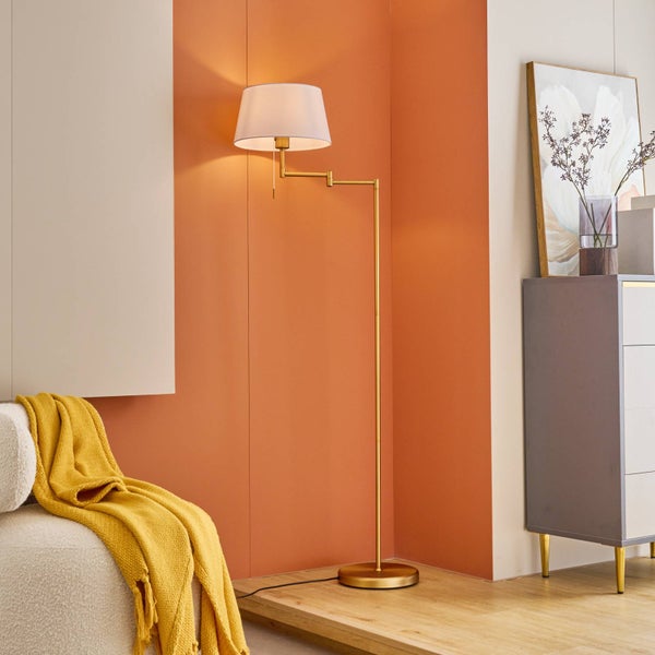 Szene mit Stehlampe, Kommode, Dekoration und Decke für ein helles, organisiertes Ambiente.