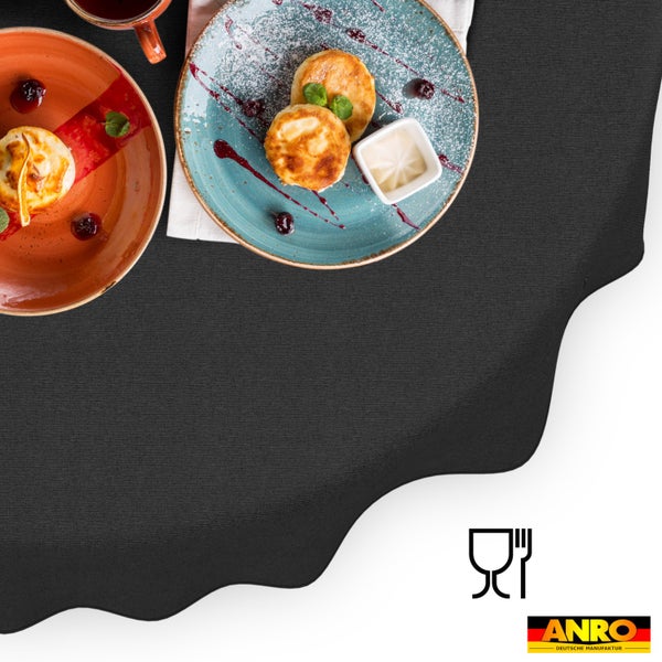 Dunkle Tischdecke mit Wellenrand, lebensmittelecht, dekoriert mit Tellern und Speisen, ANRO Logo.