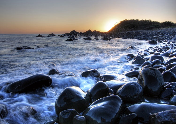 Küstenlandschaft mit Felsen und Meer bei Sonnenuntergang