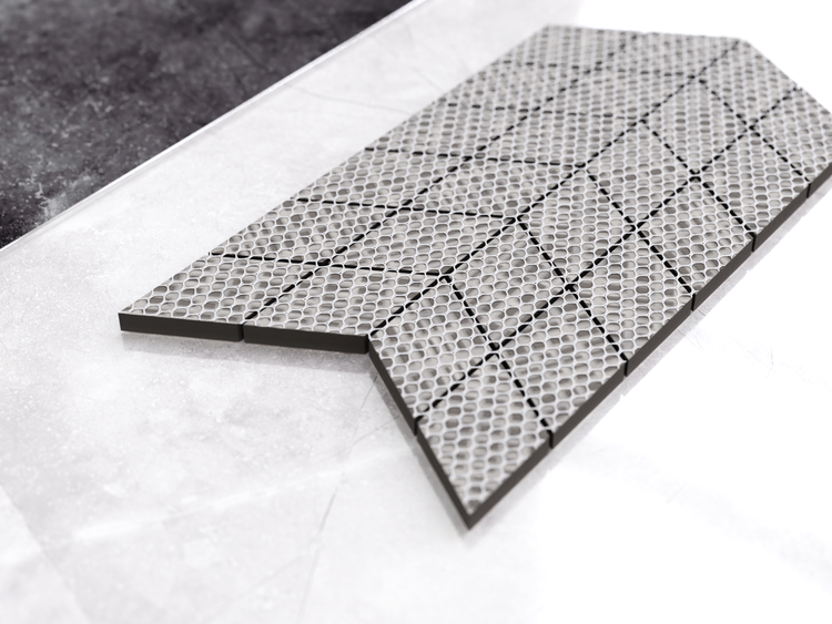 Mosaikfliese in Pfeilform mit strukturierter Metalloberfläche.