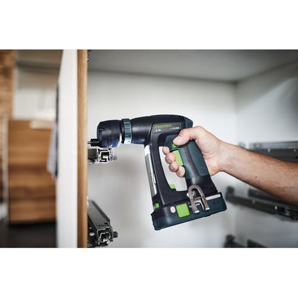 Eine Hand hält einen Festool Akku Exzenterschrauber bei der Montage von Schubladenschienen in einem Schrank.