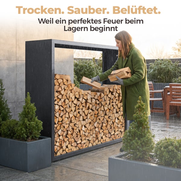 Eine Frau stapelt Brennholz in ein schwarzes Kaminholzregal aus Metall auf einer Terrasse.