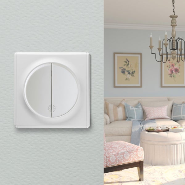 Ein runder Jalousieschalter zur Unterputzmontage an der Wand, präsentiert vor einem stilvoll eingerichteten Wohnzimmer im klassischen Design.