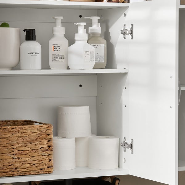 Einblick in einen weißen Badezimmerschrank mit Reinigungsmitteln und Toilettenpapier