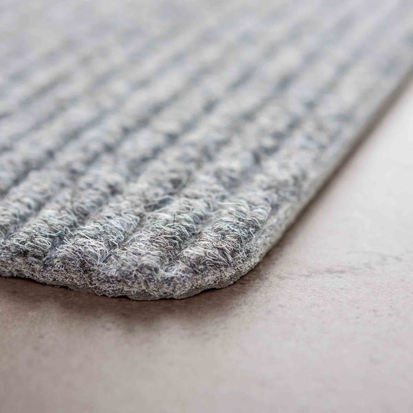 Detailansicht einer grauen Fußmatte mit Rippenstruktur