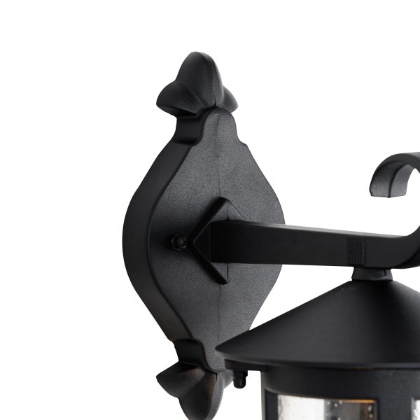 Detail der Wandhalterung einer klassischen schwarzen Außenwandleuchte aus Metall.