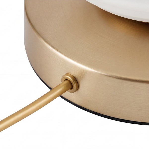 Detailansicht eines runden Lampenfußes aus gebürstetem Metall in Messingoptik.