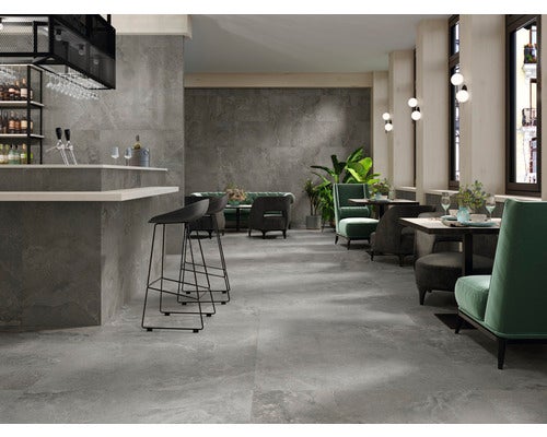 Innenraum mit grauen Bodenfliesen im Restaurantbereich.