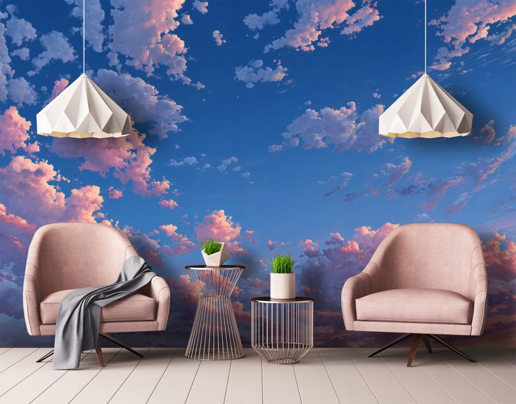 Dekoratives Interieur mit zwei Sesseln, zwei Beistelltischen und zwei Pendelleuchten vor einer Wolken Tapete.