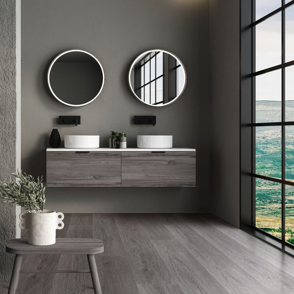Modernes Badezimmer mit Doppelwaschtisch, holzoptik Unterschrank, zwei runden LED Spiegeln und raumhohem Fenster mit Landschaftsblick.