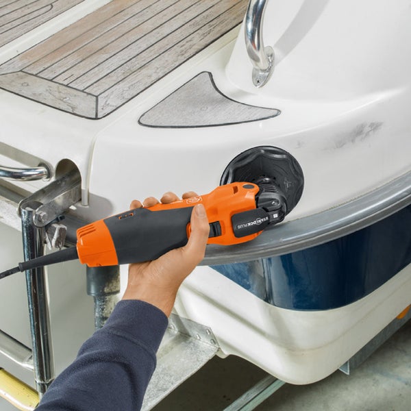 Eine Hand poliert mit einem Elektrowerkzeug ein Boot.