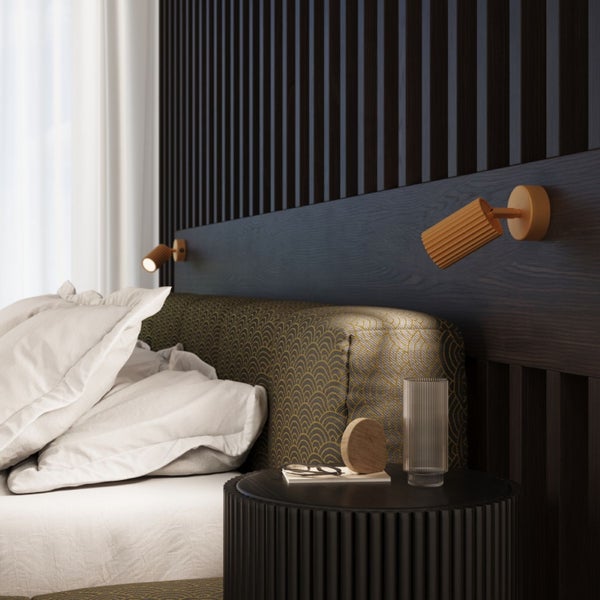 Schlafzimmer mit Bett, Nachttisch und Wandleuchten