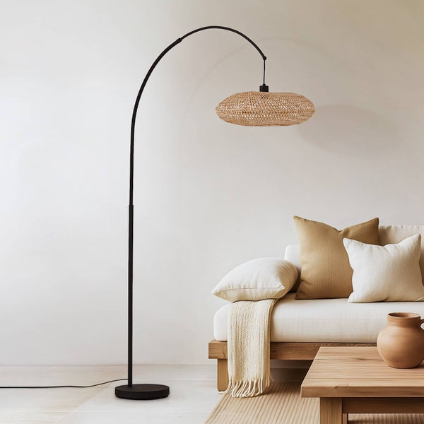 Bogenleuchte mit Lampenschirm aus Rattan neben einem Sofa