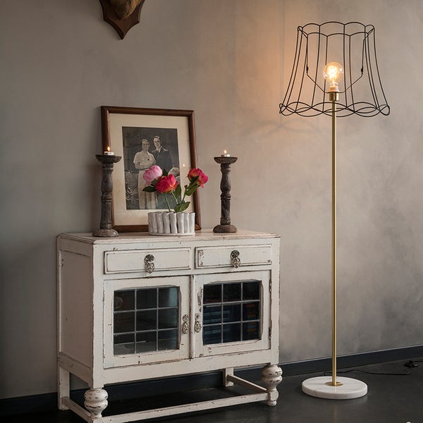 Dekoratives Interieur mit einem Schrank, einer Stehlampe und dekorativen Elementen