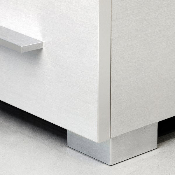 Detailansicht eines modernen Badezimmerschranks mit Metallfüßen und Griffleiste.