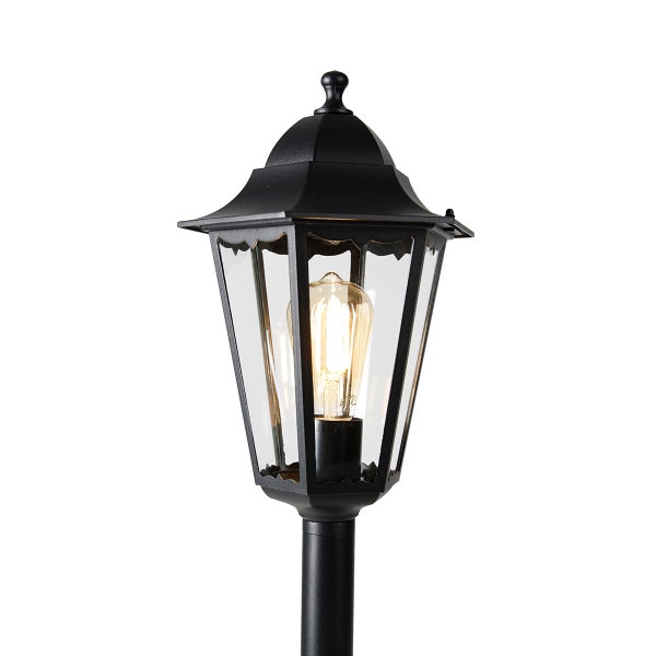 Klassische Außenleuchte in Laternenform aus Metall und Glas mit leuchtendem Leuchtmittel.