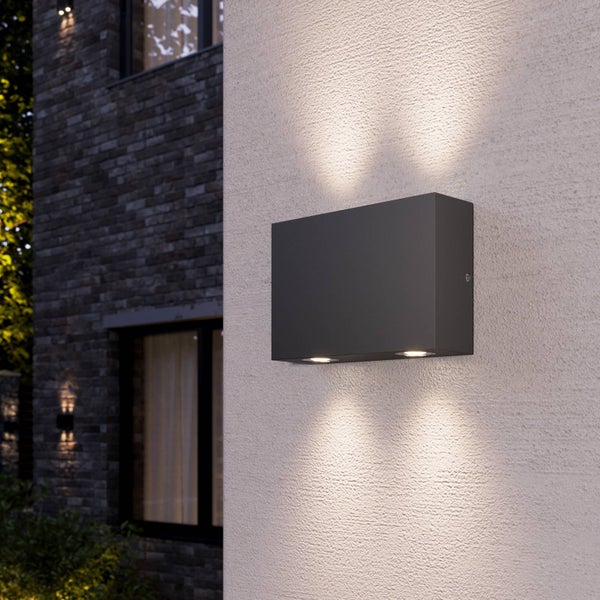 Moderne rechteckige Außenwandleuchte aus strukturiertem Metall an einer verputzten Wand, minimalistische Fassadenbeleuchtung.