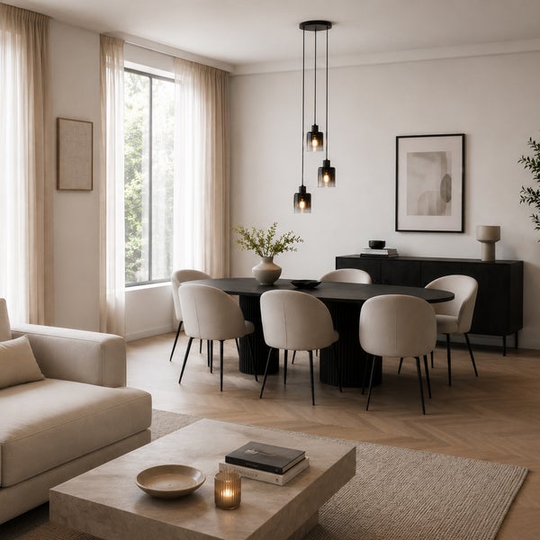 Ein helles, modernes Esszimmer mit einem ovalen schwarzen Tisch, gepolsterten Stühlen und einer dreiflammigen Pendelleuchte in einem offenen Raum.