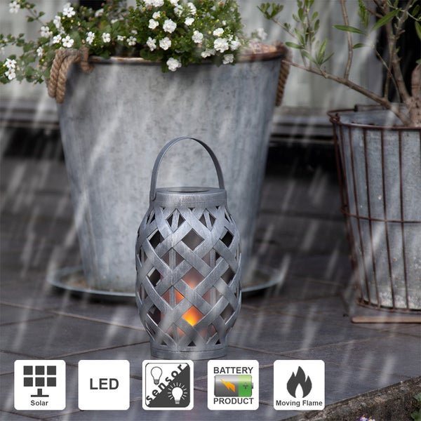 Dekorative graue Solarleuchte mit Tragegriff und Gittermuster steht auf Pflastersteinen