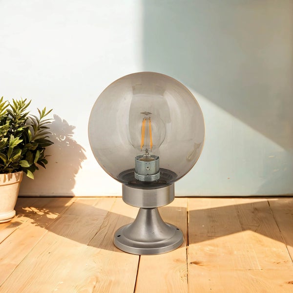 Dekorative Kugelleuchte mit einem runden Lampenschirm auf einem Sockel