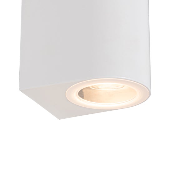 Weiße zylindrische Wandleuchte mit quadratischer Basis und nach unten gerichteter Lichtquelle.