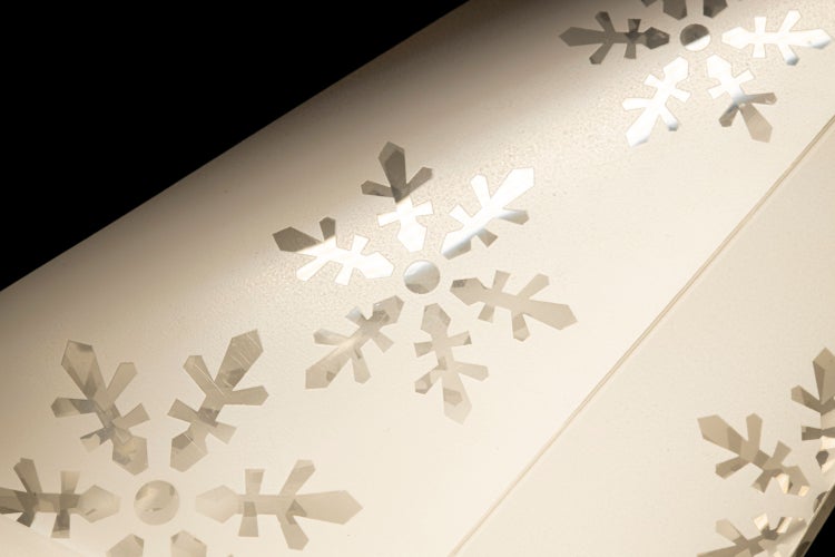 Weihnachtsbaum in einem braunen Weihnachtsbaumständer aus Metall mit Dekoration.