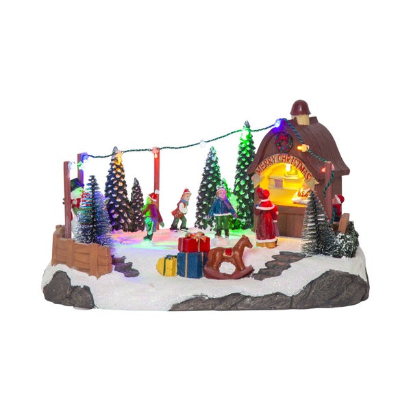 Weihnachtsdorf-Szene mit Figuren, Bäumen, Geschenken und Beleuchtung