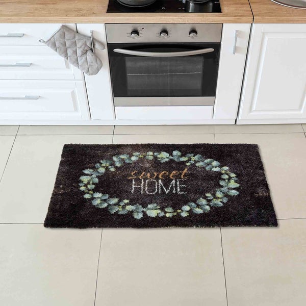 Dunkelbrauner Teppich mit dem Schriftzug „Sweet Home“ und Blattkranz in einer Küche
