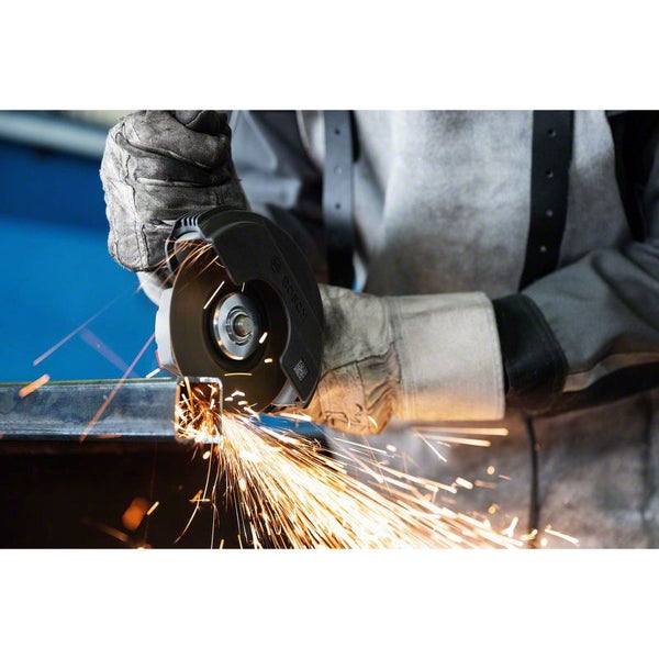 Eine Person verwendet einen Winkelschleifer zum Schneiden von Metall, wobei Funken sprühen.