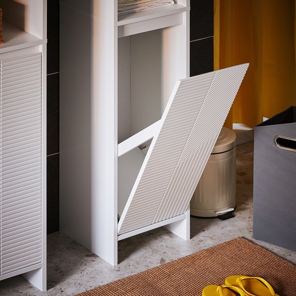 Badezimmer mit einem weißen Wäschekipper mit geöffneter Klappe