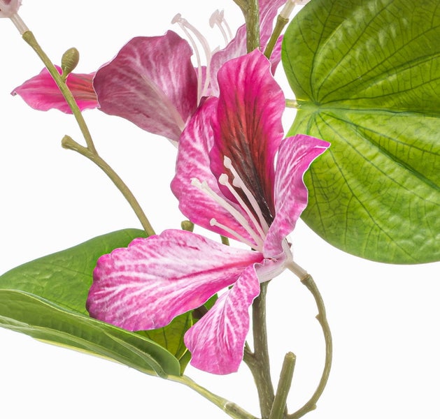 Detailansicht eines grünen Kunstpflanzenzweigs mit strukturierten Blättern und sichtbaren Blattadern.