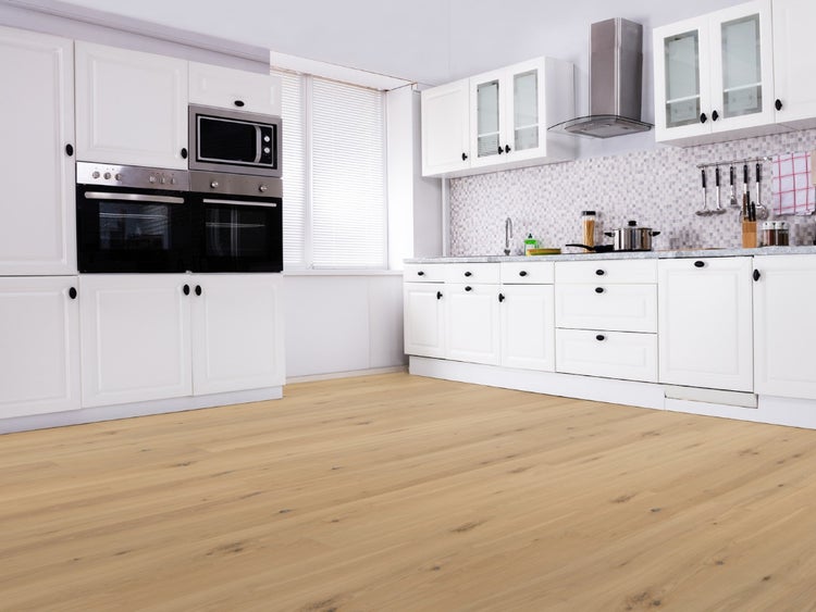 Helle, moderne Küche mit Einbauschränken und einem Bodenbelag in Holzoptik mit natürlicher Maserung.