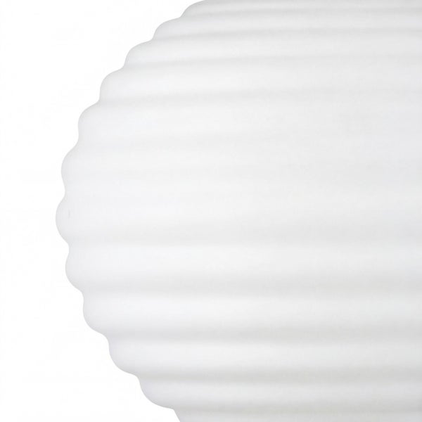 Nahaufnahme einer weißen Oberfläche mit horizontaler Rippenstruktur oder Wellenoptik.