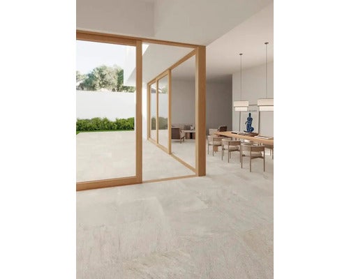 Heller Wohnraum mit Esstisch, Stühlen und großformatigen Fliesen