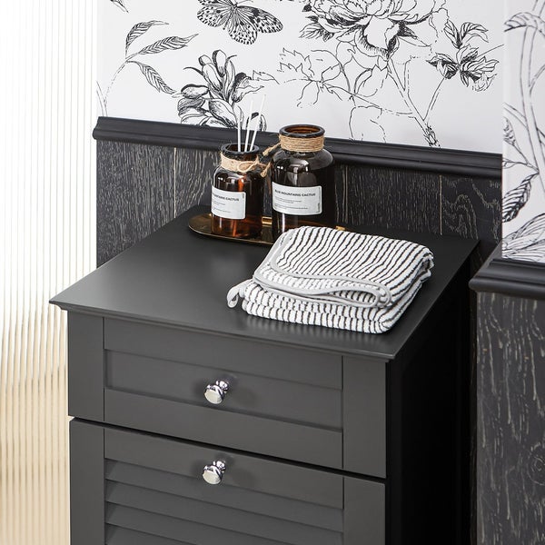 Detailaufnahme eines Badezimmerschranks mit Handtüchern und Dekoration