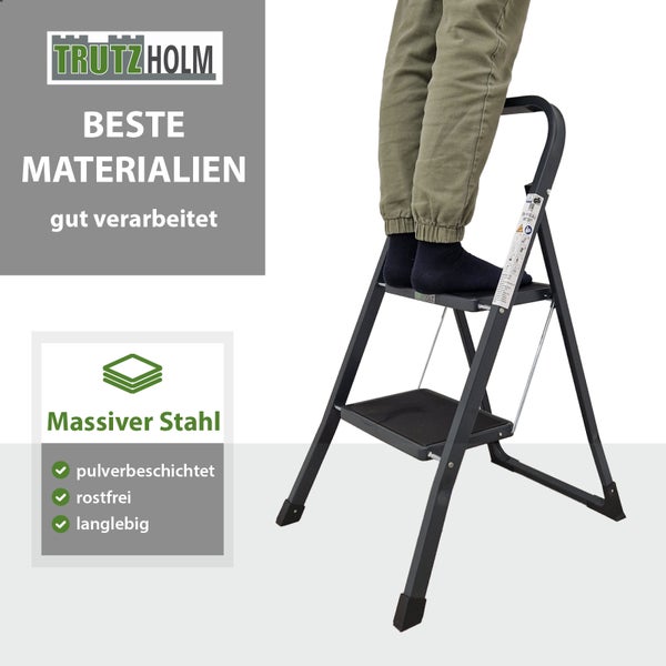 Eine Person steht auf einer pulverbeschichteten Stahlklapptrittleiter von Trutzholm mit zwei Stufen.