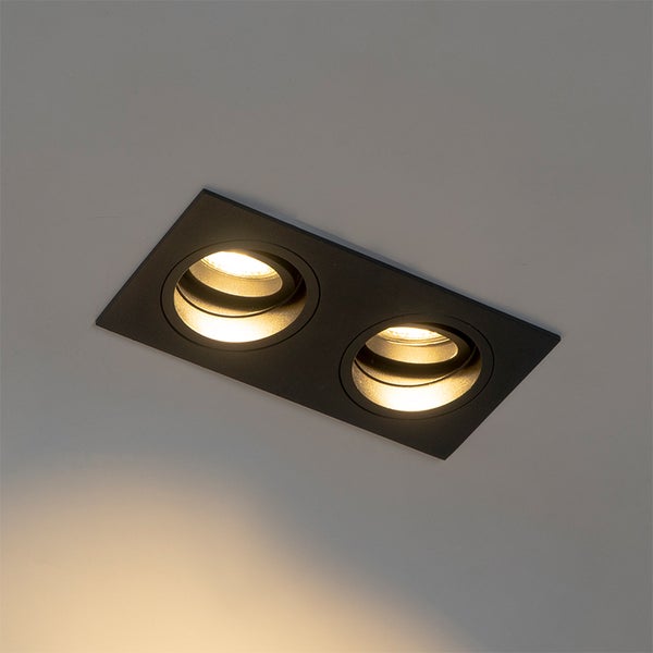 Zweiflammiger Einbaustrahler in Schwarz mit warmweißem Licht an einer Decke.