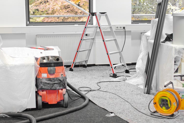 Raum mit Leiter, Staubsauger und Kabeltrommel für Renovierungsarbeiten