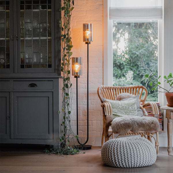 Helle Wohnungseinrichtung mit Stehlampe, Rattansessel, Ottomanen und Dekorationen