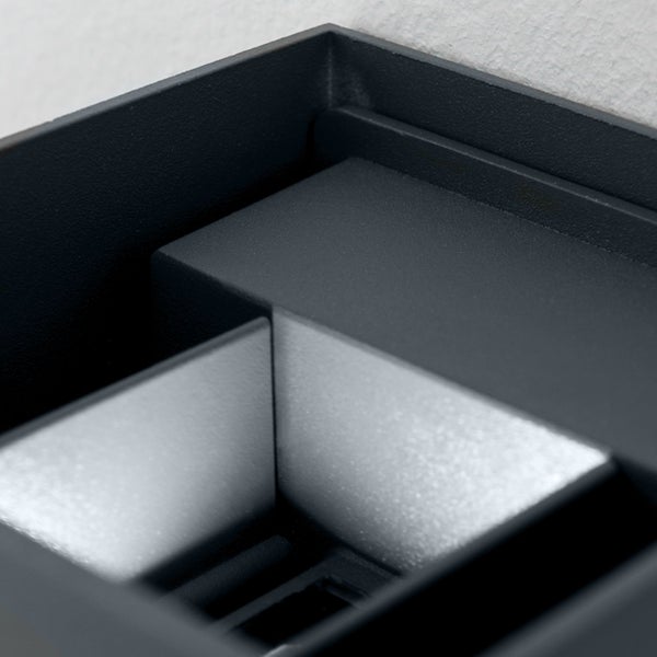 Nahaufnahme einer modernen Wandleuchte mit matter Oberfläche und integriertem Metallreflektor.